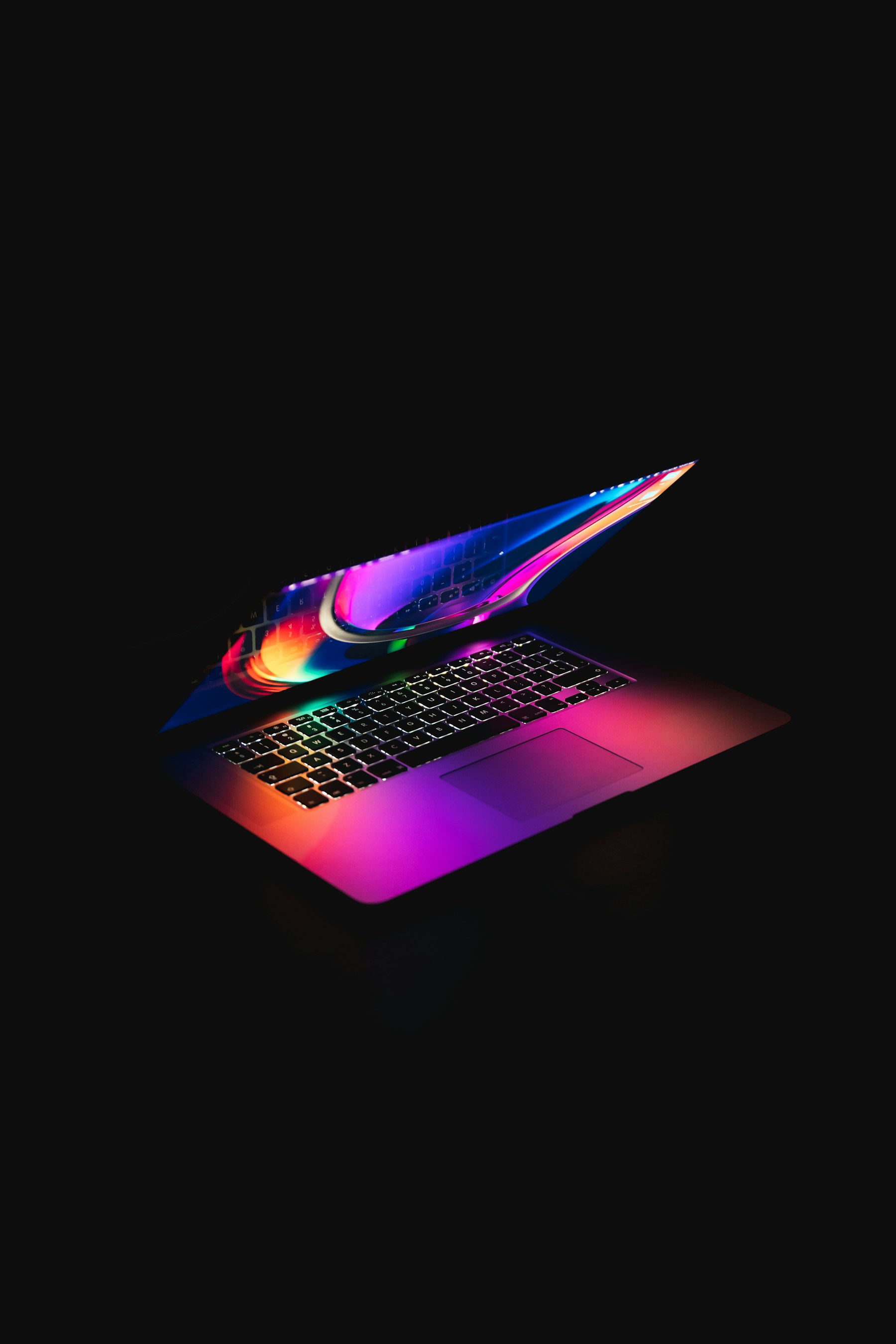 MacBook Pro in dunkler Umgebung mit farbigem Licht